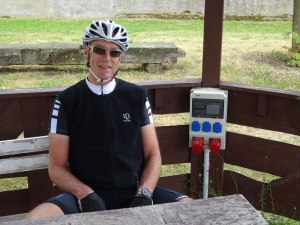 A covered bench, with an e-bike charging station.  E-bikes are big here.